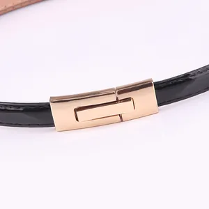 Ceinture fine en cuir verni noir pour femme avec une élégante boucle en métal doré chic