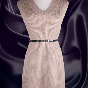Fine ceinture en cuir noir brillant avec boucle dorée rectangulaire sur robe en maille