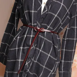 Deep red brown thin genuine leather belt with a knot design on a black and white checkered dress