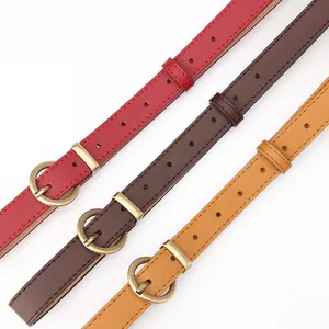 Three skinny faux leather belts in red, brown, and yellow with vintage round metal buckles