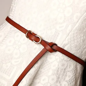 Slim brown leather belt for women featuring a gold double-ring buckle on white lace