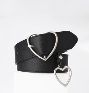 Detail of classic black leather belt featuring a silver heart buckle and hanging charm