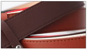 Detail of premium brown leather belt with tri-color webbing and silver rivet