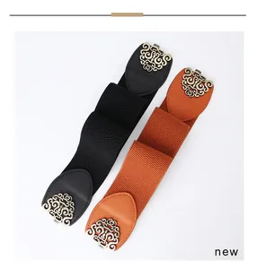Detail of wide elastic belts in black and brown with vintage hollowed-out metal buckles