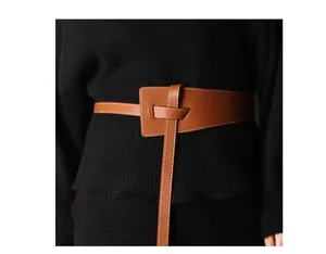 Detail of brown leather waist belt featuring white contrast stitching and knotted design