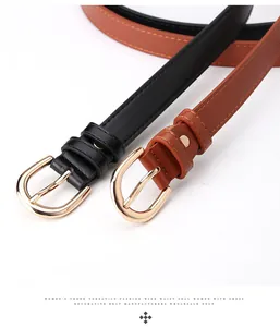 Close-up of black and brown faux leather belts with round golden metal buckles