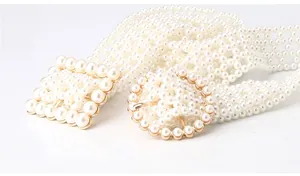 Detail of woven white pearls on a decorative waist chain with gold buckle accents