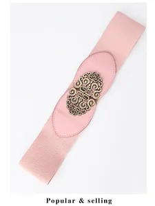 Close-up of pink elastic wide belt with vintage bronze hollowed metal buckle detail