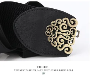 Detailed close-up of a women elastic wide belt with a vintage gold floral metal buckle
