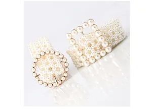 Close-up of elegant woven imitation pearl belt with metallic round and square buckles