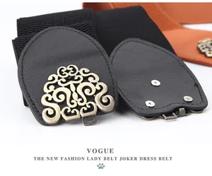 Detail of vintage bronze-tone filigree buckle on a wide elastic waist belt for women