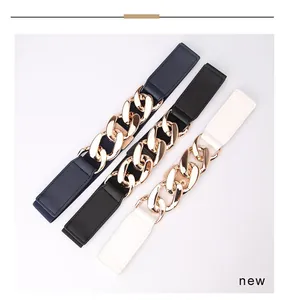 Close-up of three wide elastic waist belts featuring oversized golden metal link chains
