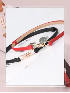 Close-up of red and black skinny belts featuring elegant interlocking gold metal buckles