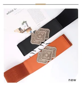 Detail of vintage carved metal buckles on women's elastic waist belts in black and brown