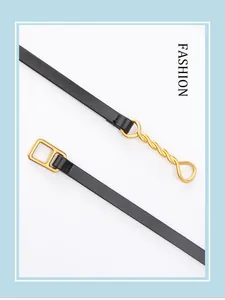 Detail of thin black leather belt featuring a gold square buckle and twisted chain link