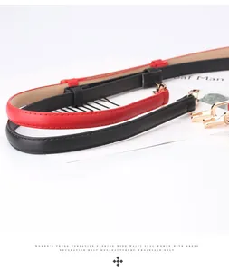 Detail of red and black skinny belts with elegant gold metal hook buckles for dresses