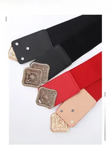 Detail of vintage carved metal buckle on wide elastic belt with faux leather stitching