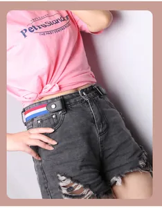 Detail of red white and blue striped elastic no-buckle belt on grey denim shorts