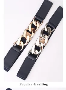 Detail of wide elastic belts featuring thick metallic gold and silver chunky chains