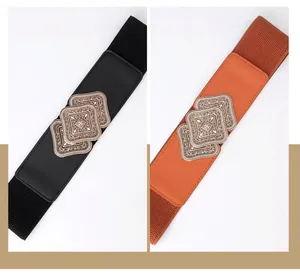 Close-up of vintage carved metal buckles on wide elastic belts in black and brown