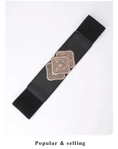 Close-up of vintage engraved gold buckles on black elastic wide waist belt