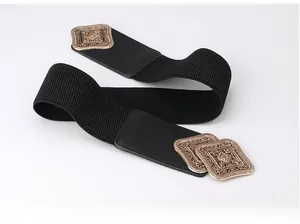 Detailed macro shot of vintage bronze square buckle with carved textures on black belt