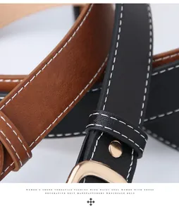 Dettaglio macro di cinture in pelle con cuciture bianche e fibbia dorata da donna