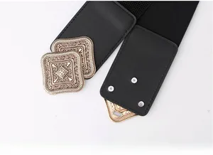 Detail of vintage golden interlocking buckle with geometric hollow carvings on elastic belt