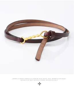 Detail of slim dark brown leather belt with gold twist buckle for women dresses