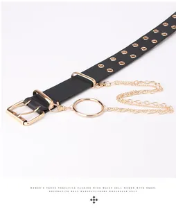 Detalle de cinturón ancho negro con ojales dorados y triple cadena metálica decorativa