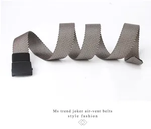 Détail de la ceinture en toile à rayures noires et blanches avec boucle noir mat