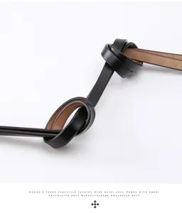 Detail of a knotted black leather waist belt showing the brown inner lining and texture