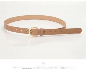 Detail view of a camel leather fashion belt with a gold horseshoe buckle on white background