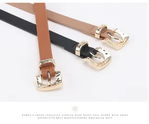 Detailed view of women's skinny belts in black and brown with gold hammered metal buckles