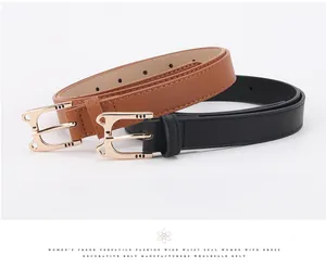 Detail of trendy cat-shaped gold buckle on black and brown leather belts for women