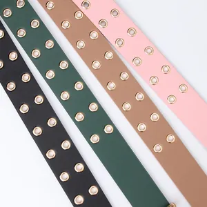 Women's double grommet faux leather belts with gold metal hardware in four stylish colors