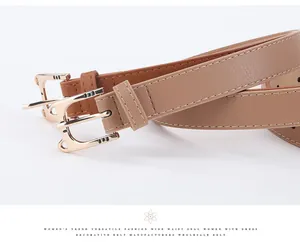 Detailed close-up of light brown PU leather belt with gold cat buckle and fine stitching