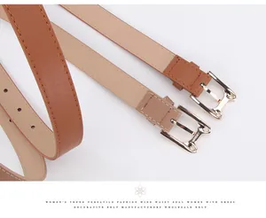 Close-up of golden cat-shaped metal buckles on stylish brown and tan PU leather belts