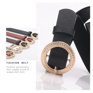 Close-up of golden round buckle with woven texture on a fashion slim leather belt