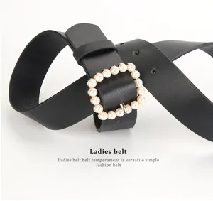 Detailed view of black leather belt featuring a square buckle with elegant pearl accents