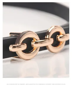 Close-up of interlocking gold rings on a slim black PU leather belt for women