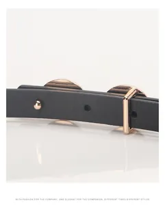 Detail of slim black leather belt with rose gold buckle and lychee texture