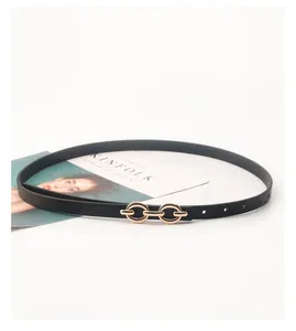 Close-up of black leather slim belt with elegant interlocking gold metal double ring buckle