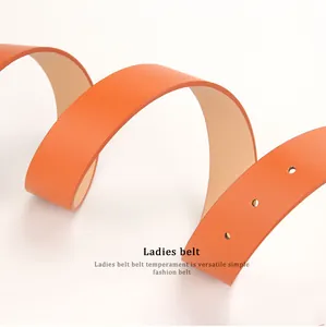 Close-up of bright orange lychee textured leather ladies belt with needle buckle holes
