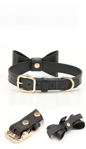 Detailed view of black PU leather pet collar with gold metal buckle and bow tie accent