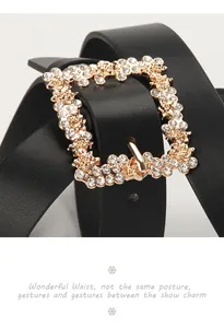 Macro shot of woman's black leather belt featuring a luxury rhinestone-studded gold buckle