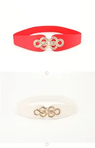 Detail of red and white elastic waist belts featuring golden infinity metal buckles