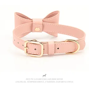 Close-up of pink PU leather dog collar with large bowknot and golden metal D-ring hardware
