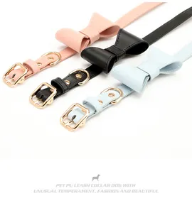 Close-up of PU leather pet collars with bows and gold metal buckles in pink black and blue