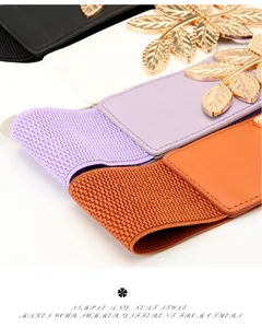 Detail of elastic waist belts showing gold leaf buckles in black, white, and lilac colors